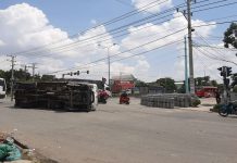 Xe tải ôm cua lật ngang, hàng chục bình gas rơi trước cây xăng ở Bình Dương