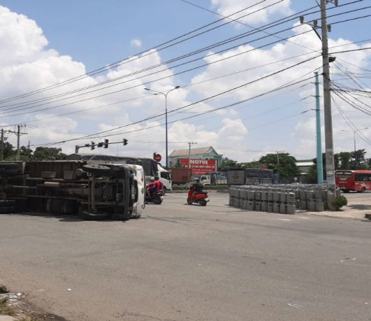 Xe tải ôm cua lật ngang, hàng chục bình gas rơi trước cây xăng ở Bình Dương